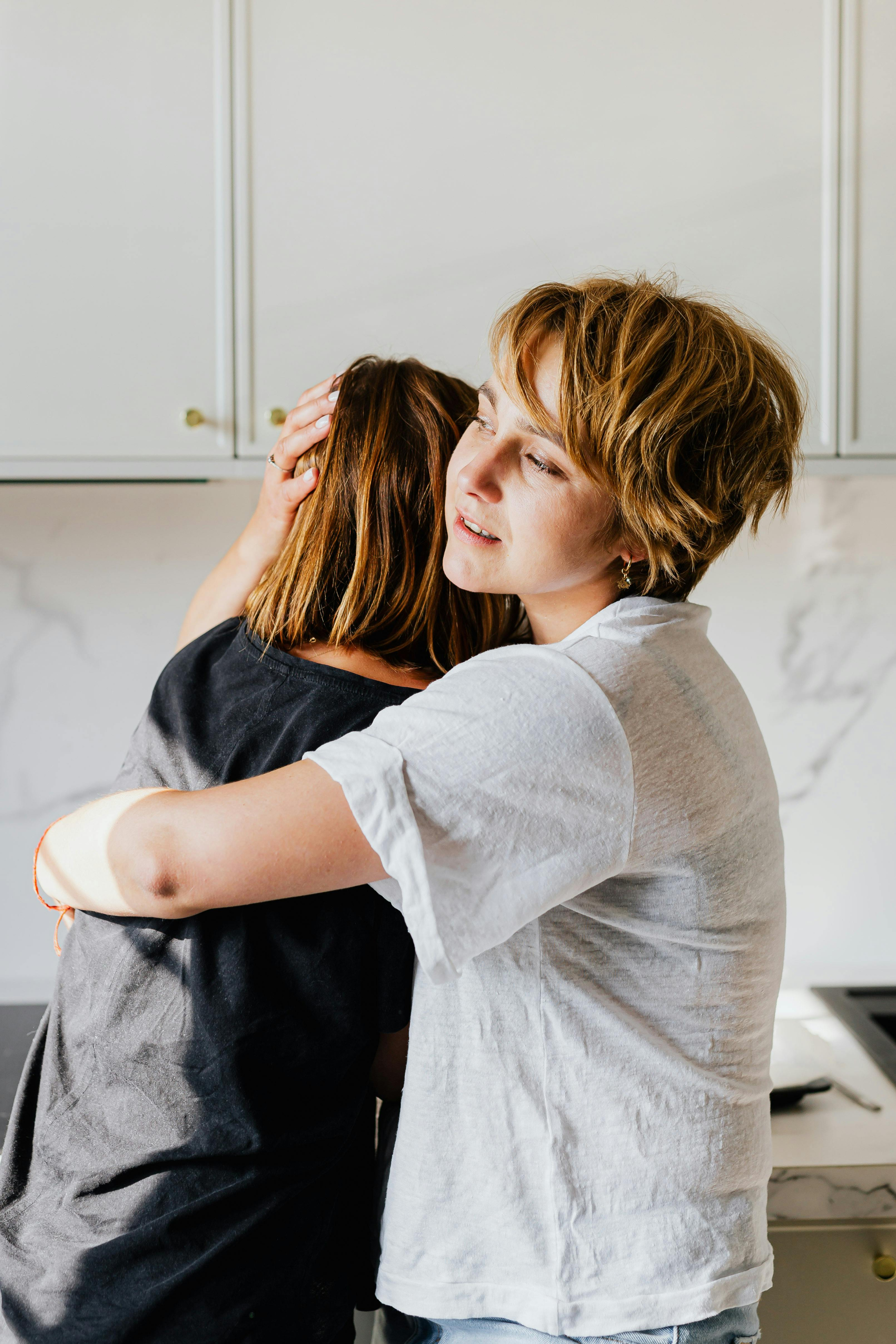 Two people embracing in a quiet, supportive moment.